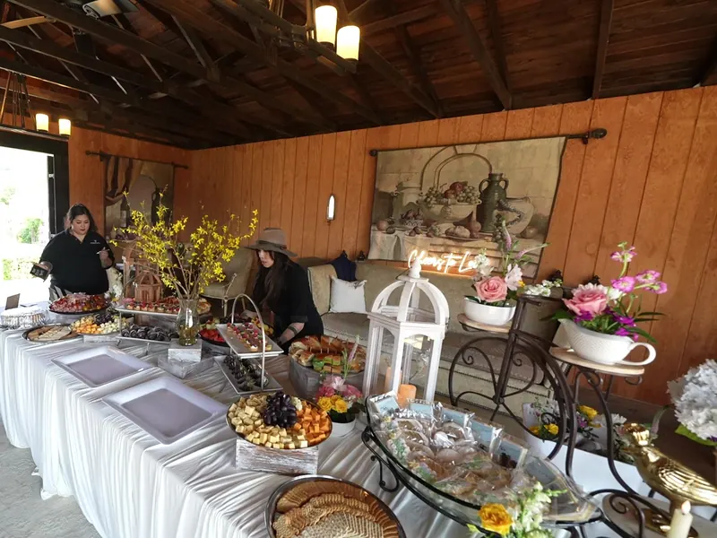 Long grazing and dessert buffet with florals inside a wood-paneled hall near Milpitas