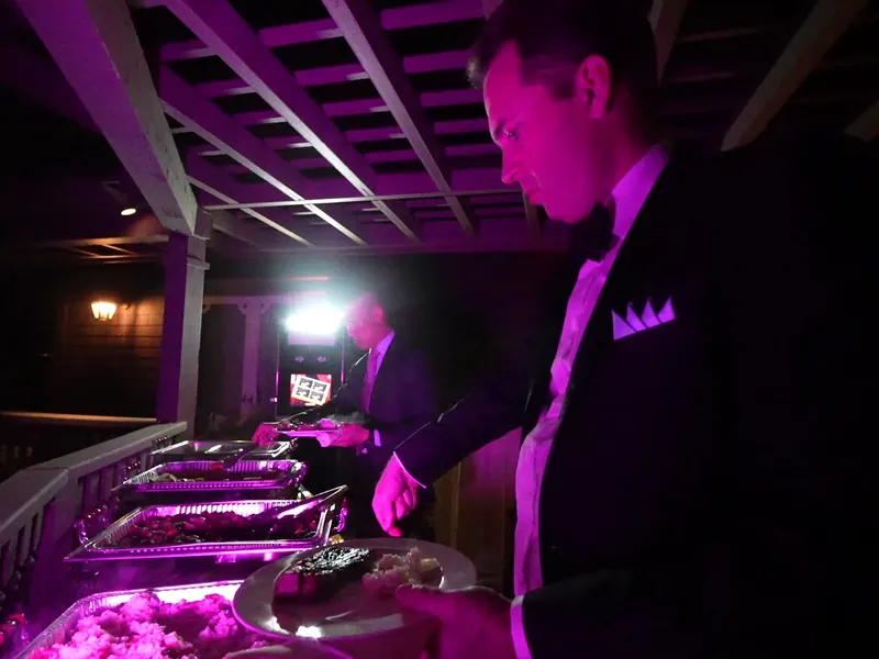 Catering staff tending chafing dishes under evening lighting at a Fremont reception