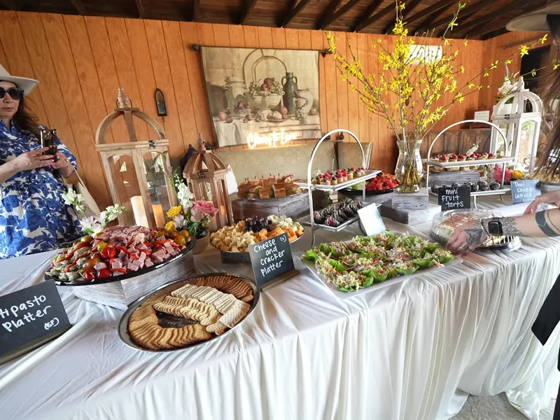 Antipasto and grazing table with chalkboard signs set along a wood wall in Union City