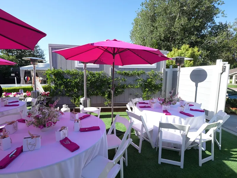 Pink linen tables and white folding chairs set for a Hayward reception