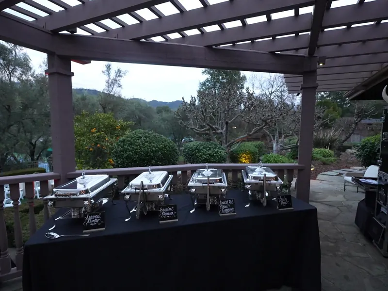 Chafing-dish buffet set under a pergola with hillside views near Milpitas