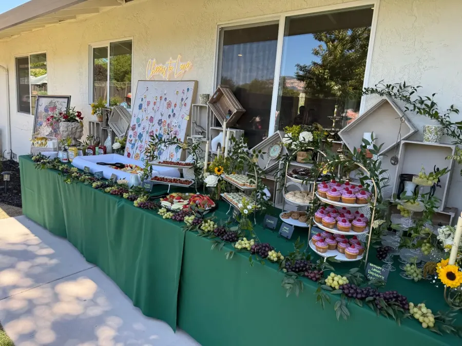 Shower sweets and grazing setup with frosted cupcakes and grape clusters against soft draped fabric — shower tablescapes from Fremont and Milpitas catering