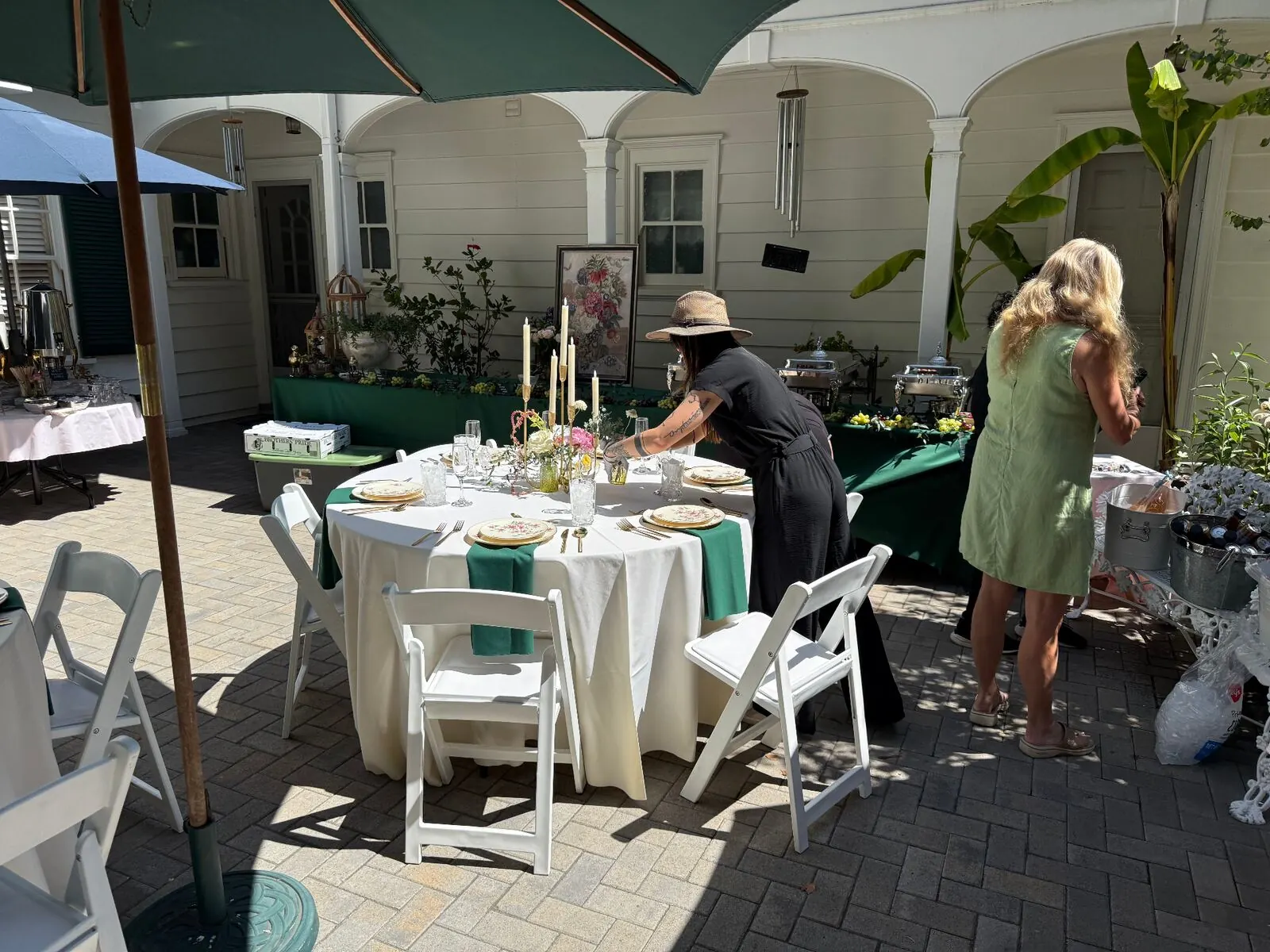 Outdoor courtyard table setup with emerald linens and elevated rentals for a Fremont event